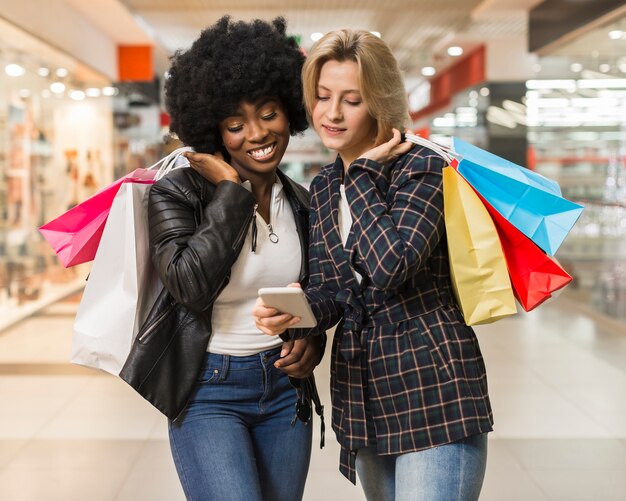 Mujeres adultas revisando un teléfono móvil