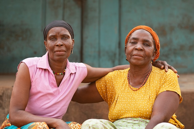 Mujeres africanas de tiro medio sentadas juntas