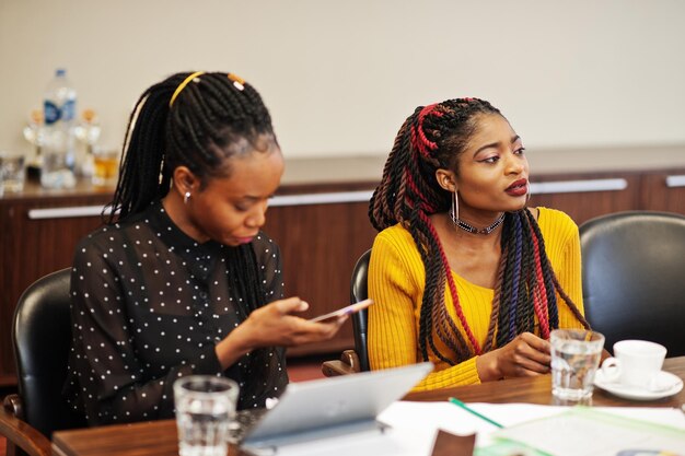 Mujeres afroamericanas colegas tripulación de divercity socias femeninas en el cargo sentarse a la mesa