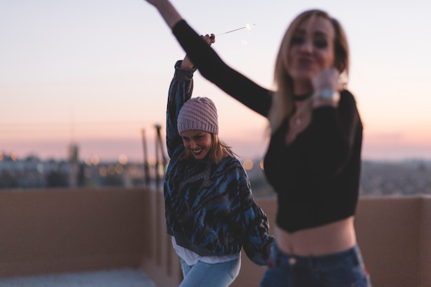 Foto gratuita mujeres alegres bailando con bengalas