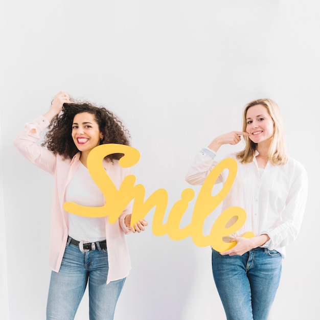 Foto gratuita mujeres alegres con escritura de sonrisa