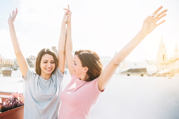 Mujeres alegres levantando la mano