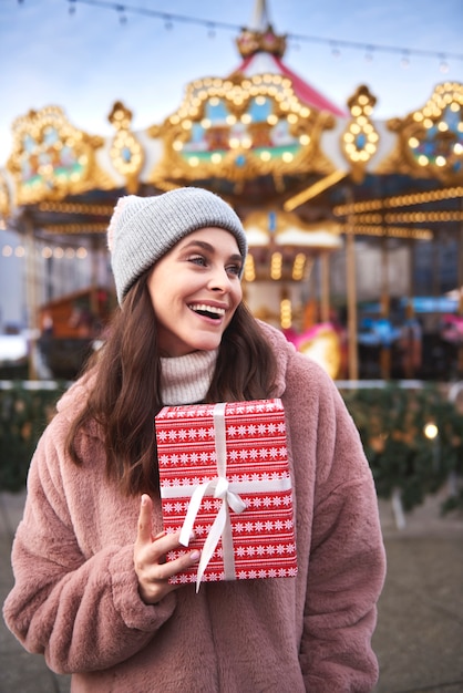 Mujeres alegres con presente en el mercado navideño