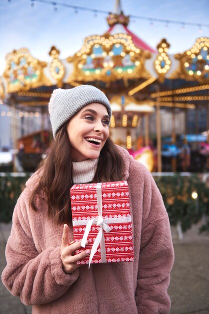 Mujeres alegres con presente en el mercado navideño