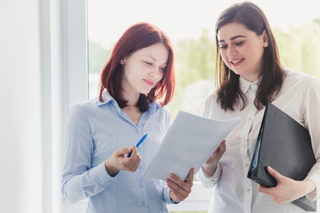 Foto gratuita mujeres alegres que trabajan con documentos