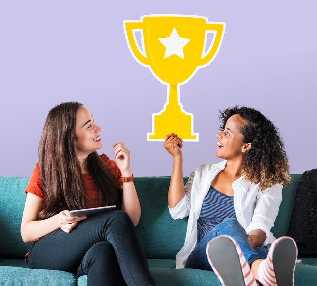 Mujeres alegres sosteniendo el icono de trofeo