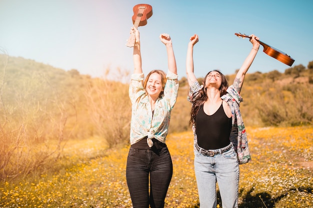 Mujeres alegres con ukeleles disfrutando del clima