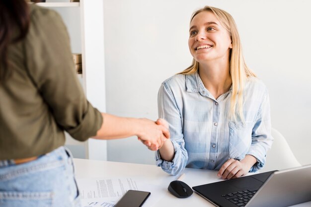 Mujeres de alto ángulo dándose la mano