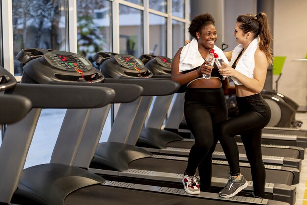 Mujeres de alto ángulo en el gimnasio hablando