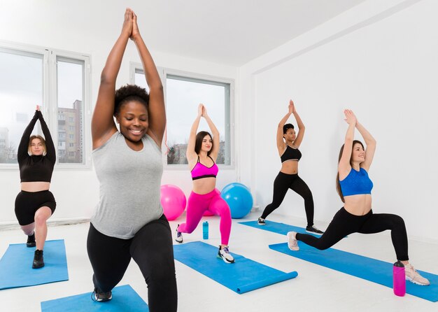 Mujeres de alto ángulo haciendo ejercicio en la estera