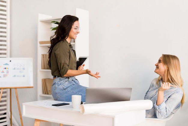 Mujeres de alto ángulo en la oficina hablando