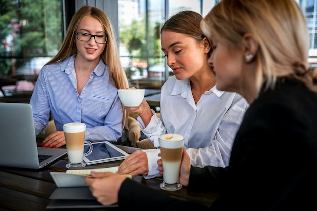 Mujeres de alto ángulo que trabajan y disfrutan del café