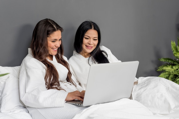 Foto gratuita mujeres de alto ángulo wathing en la computadora portátil