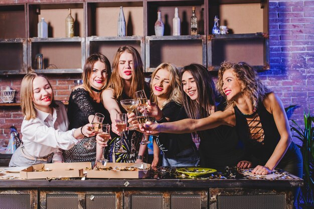 Mujeres amigos tintineando gafas