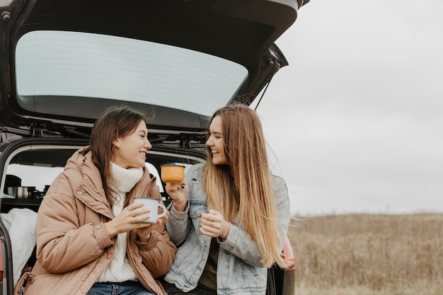 Mujeres de ángulo bajo bebiendo té caliente