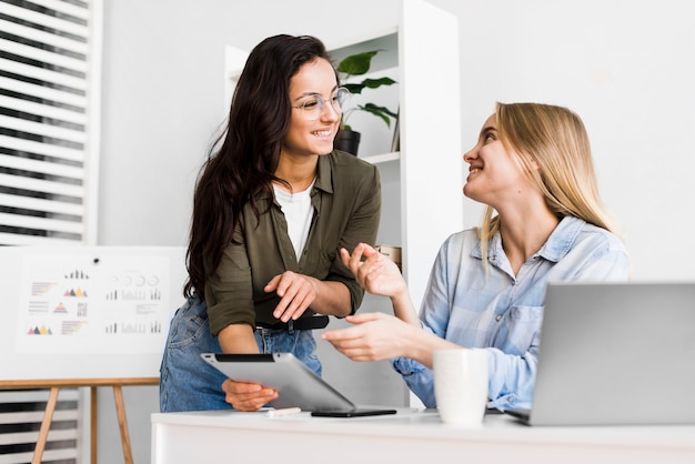 Mujeres de ángulo bajo en la oficina trabajando