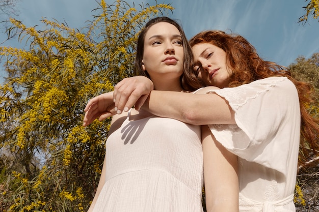 Mujeres de ángulo bajo posando juntas