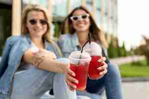 Foto gratuita mujeres animando con batidos rojos