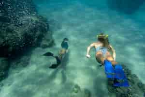 Foto gratuita mujeres apnea con aletas bajo el agua