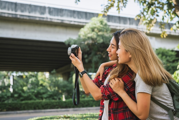 Las mujeres asiáticas del amigo del viajero hermoso feliz llevan la mochila