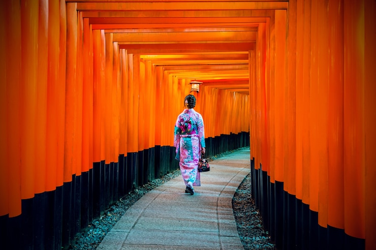 Foto gratuito mujeres asiáticas en kimonos japoneses tradicionales en el santuario fushimi inari en kyoto, japón.