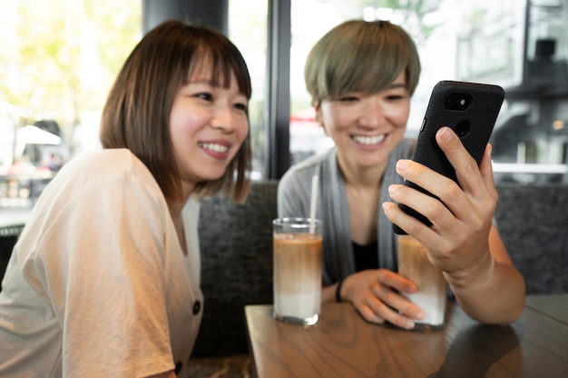 Mujeres asiáticas mirando algo en el teléfono