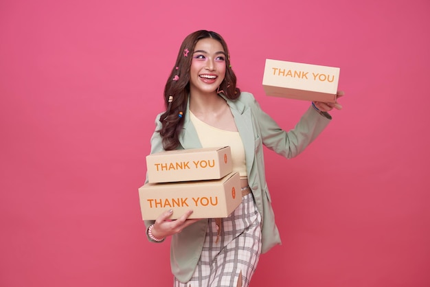 Foto gratuita mujeres asiáticas de pie sostienen una caja de embalaje lista para la entrega