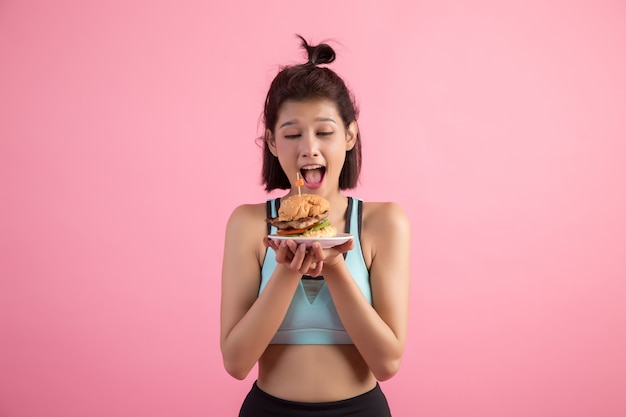 Foto gratuita las mujeres asiáticas rechazan la comida rápida por adelgazar en rosa