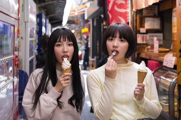 Mujeres asiáticas de tiro medio comiendo helado