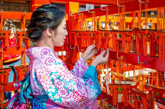 Las mujeres asiáticas vistiendo un kimono tradicional japonés visitando el hermoso santuario Fushimi Inari en Kyoto, Japón