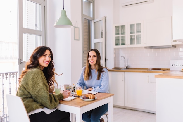 Mujeres atractivas que dibujan y que miran la cámara