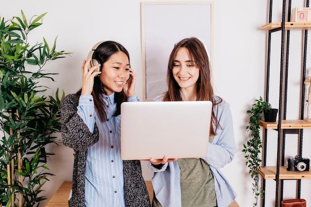 Mujeres con auriculares y portátil