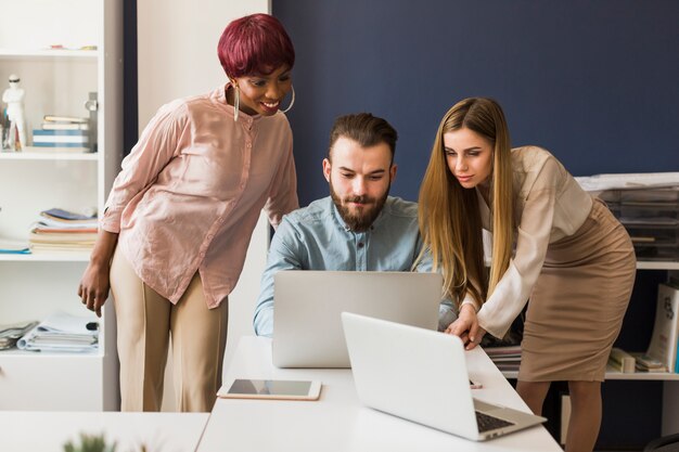 Mujeres ayudando a hombre con proyecto