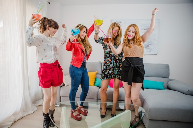 Mujeres bailando con cócteles