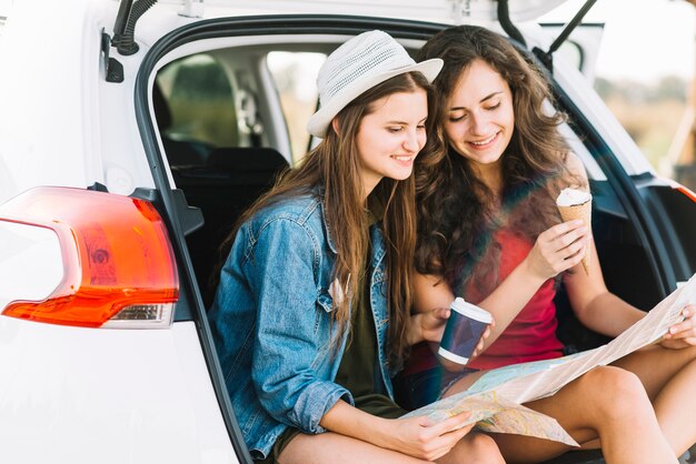 Mujeres en el baúl del auto con mapa