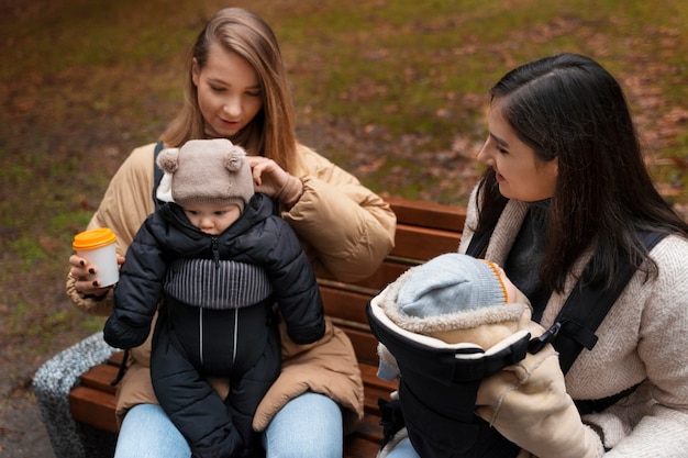 Foto gratuita mujeres con bebés en portabebés ángulo alto