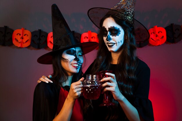 Mujeres con bebida vestidas como brujas
