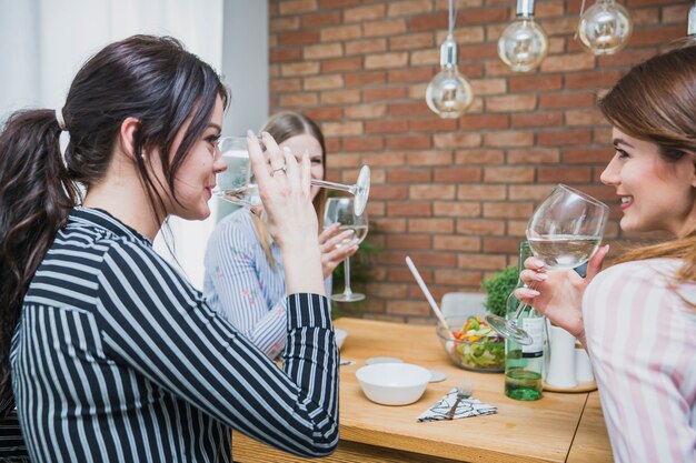 Mujeres bebiendo vino y sonriendo