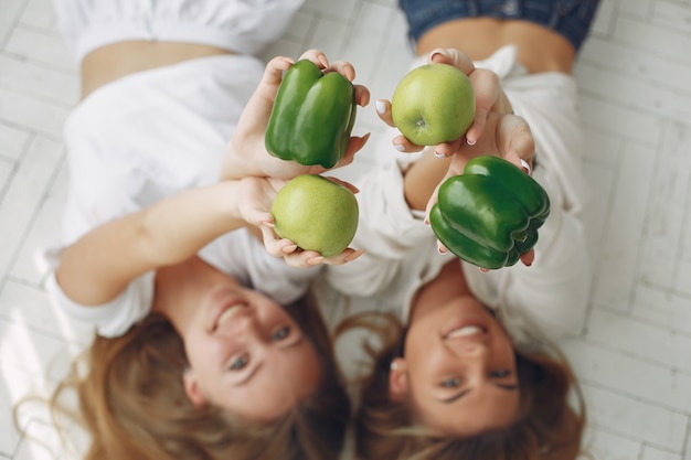 Mujeres bellas y deportivas en una cocina con verduras