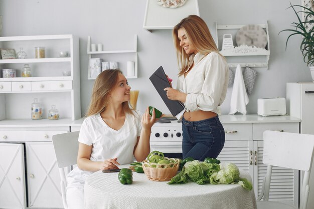 Mujeres bellas y deportivas en una cocina con verduras