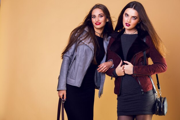 Mujeres bonitas glamorosas posando y vistiendo chaquetas de invierno casuales