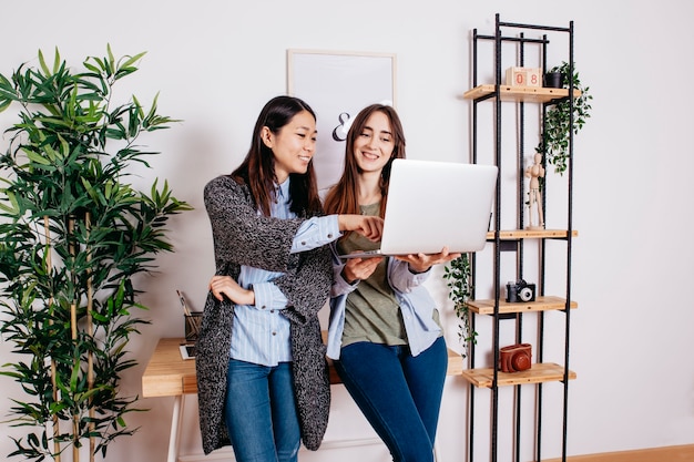 Mujeres bonitas multirraciales coworking en la computadora portátil