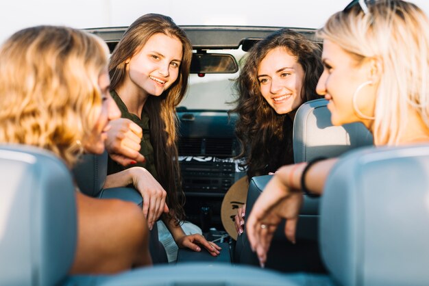 Mujeres bonitas que se sientan en cabriolet