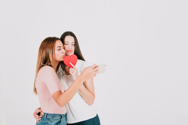 Mujeres bonitas tomando selfie con corazón