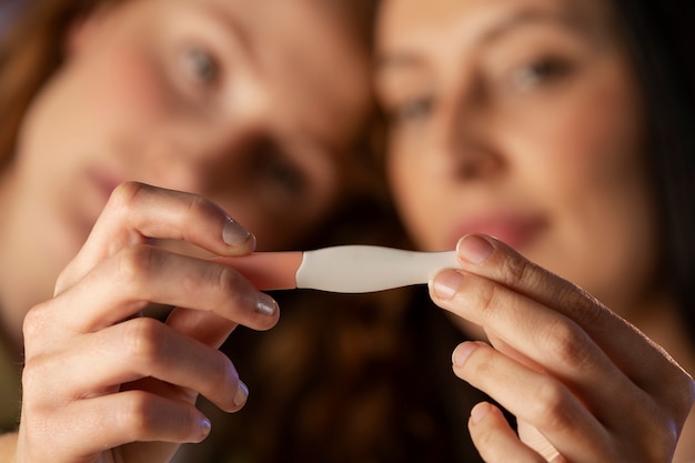 Foto gratuita mujeres borrosas que miran la prueba de embarazo