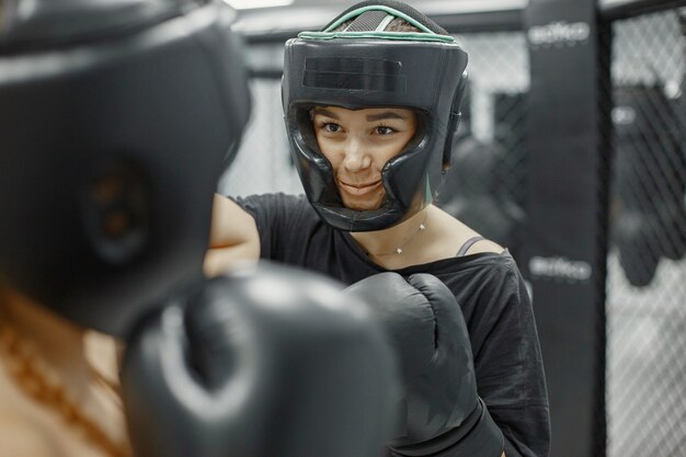 Mujeres de boxeo. Principiantes en un gimnasio. Dama en ropa deportiva negra.