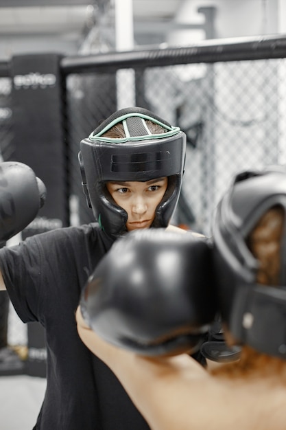 Mujeres de boxeo. Principiantes en un gimnasio. Dama en ropa deportiva negra.