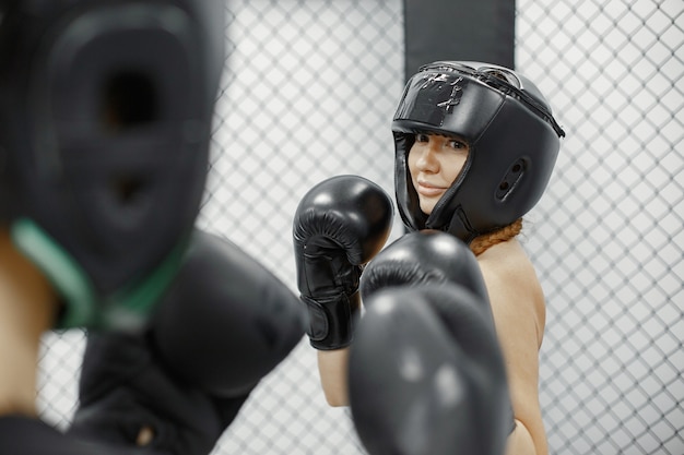 Mujeres de boxeo. Principiantes en un gimnasio. Dama en ropa deportiva negra.