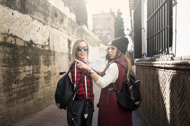 Mujeres buscando camino correcto en la calle