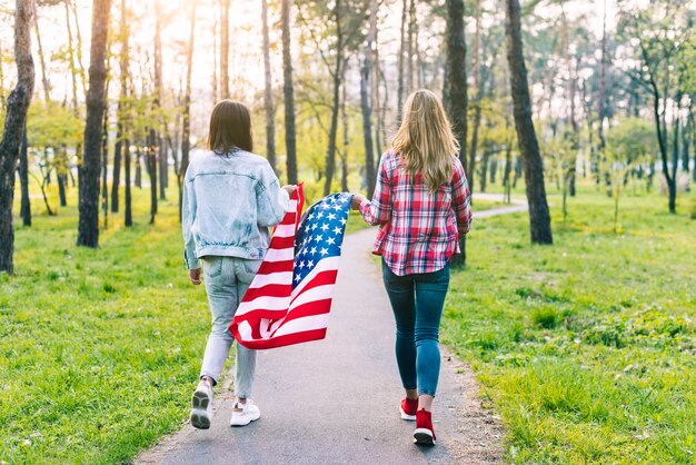 Mujeres caminando en el parque con la bandera de Estados Unidos